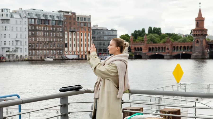 side view of young woman taking photo on pier in