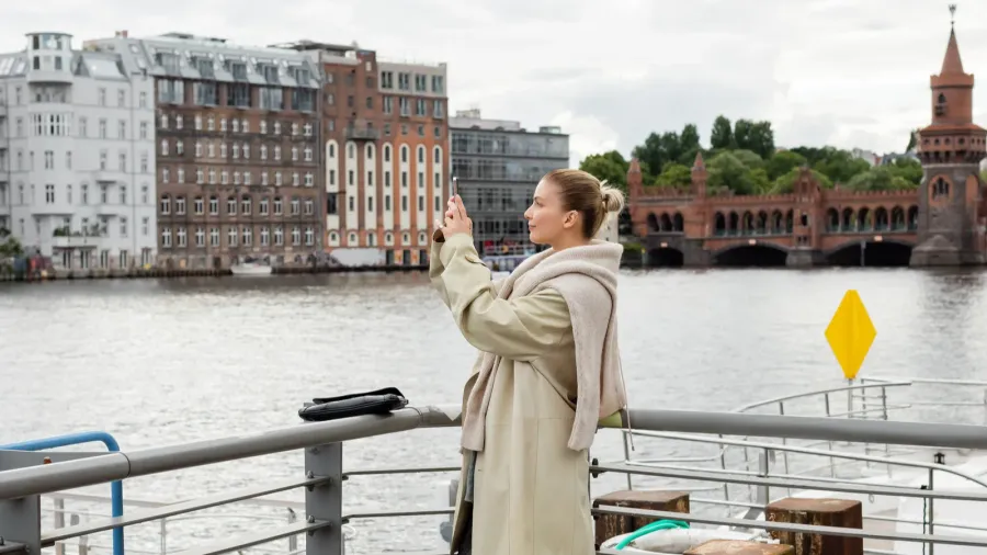 side view of young woman taking photo on pier in