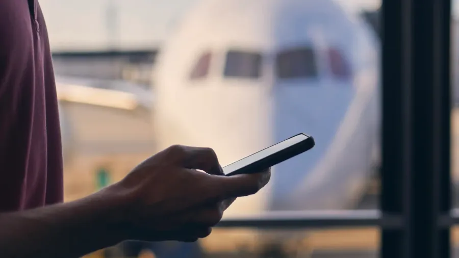 silhouette of hand of passenger while using mobile phone during