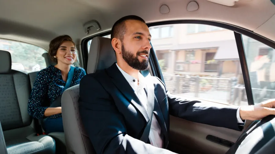 similing taxi driver talking with female passenger