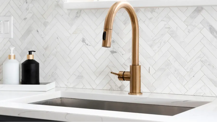 sink detail shot in a luxury kitchen with herringbone backsplash