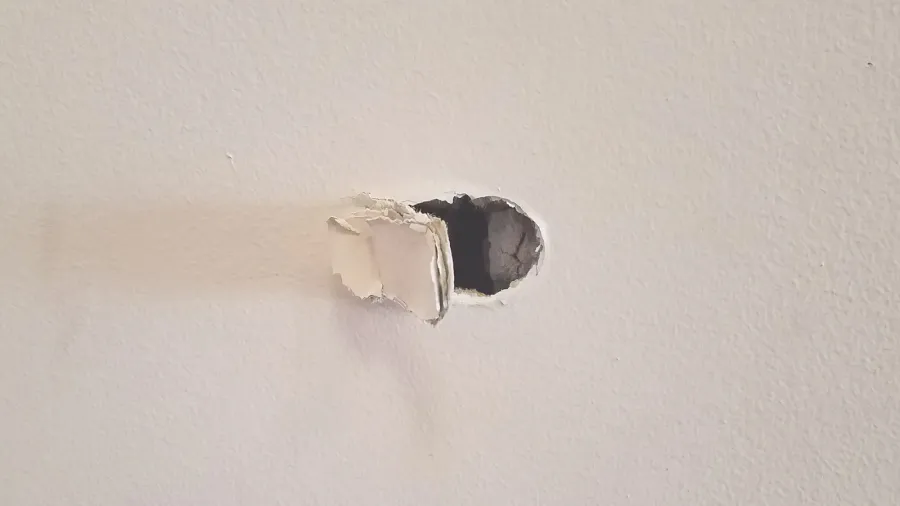 small hole damage or dent in a drywall wall