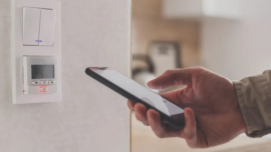 smartphone connecting to floor heating controller in kitchen remote home