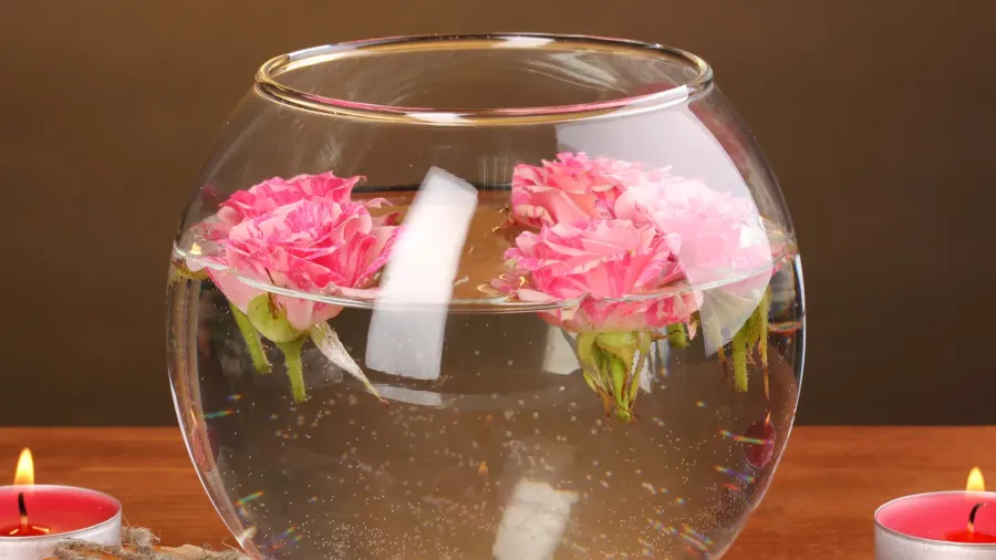 spa composition of candles soap and pink roses floating on