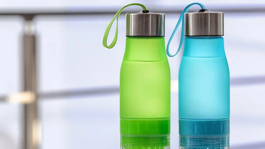 sports water bottles on table against blurred background space for