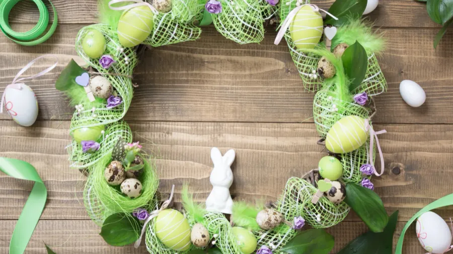 spring wreath with flowers and eggs easter background top view