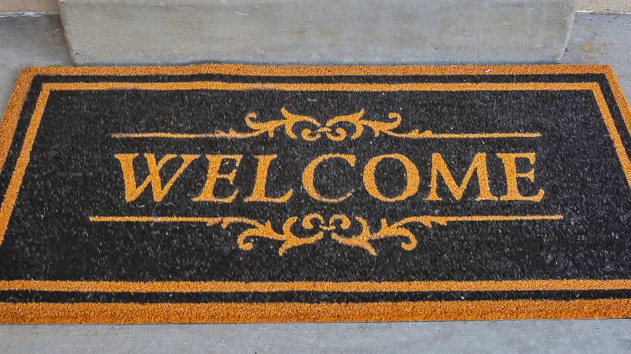 square frame black and brown welcome doormat by the doorstep