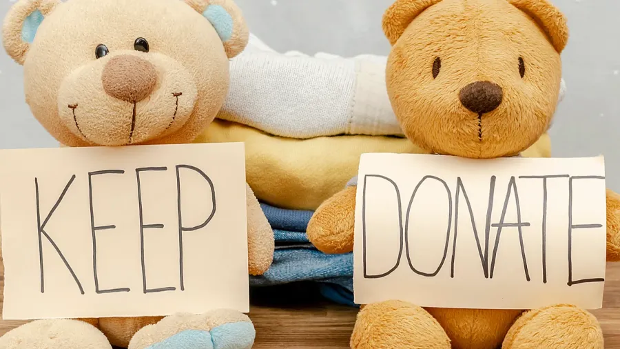 stack of old baby children clothesteddy bear toyssorted into keep