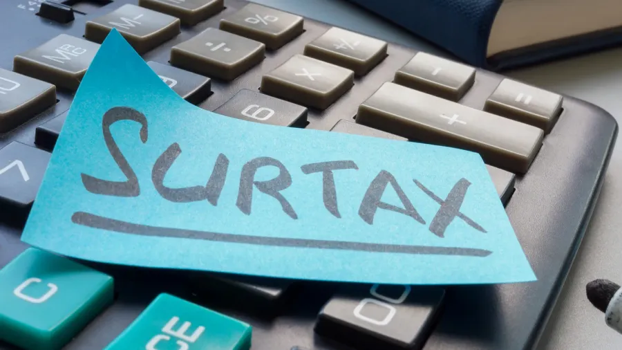 sticker with the inscription surtax or tax surcharge on the