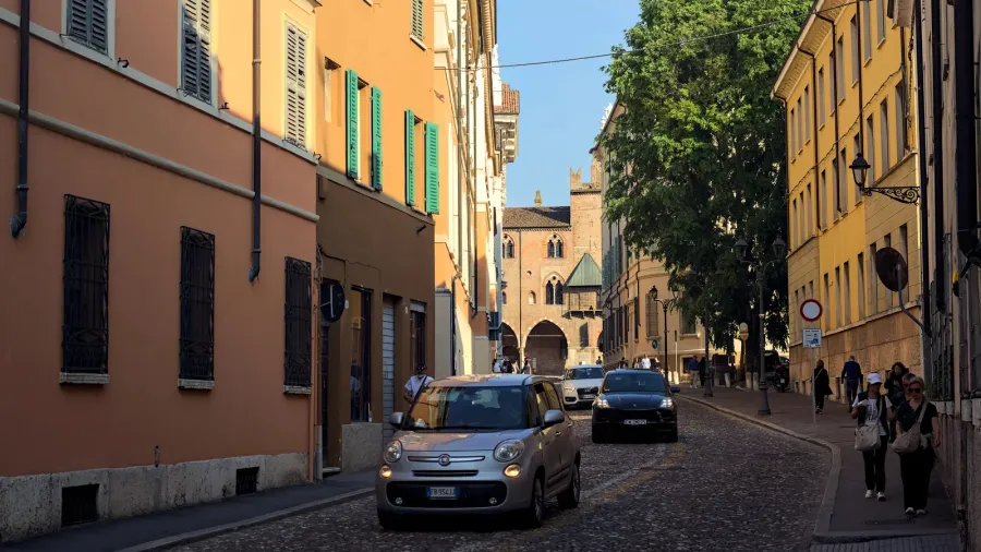 street bordered by tall building and cars passing by in