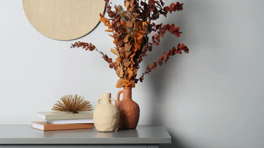 stylish vases dried eucalyptus branches and books on grey table