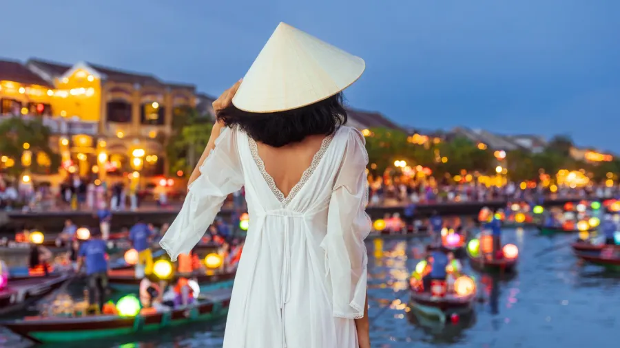 stylish woman in a flowing white dress and conical hat