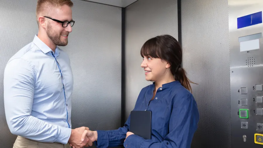 successful young business colleague in formalwear smiling and shaking each
