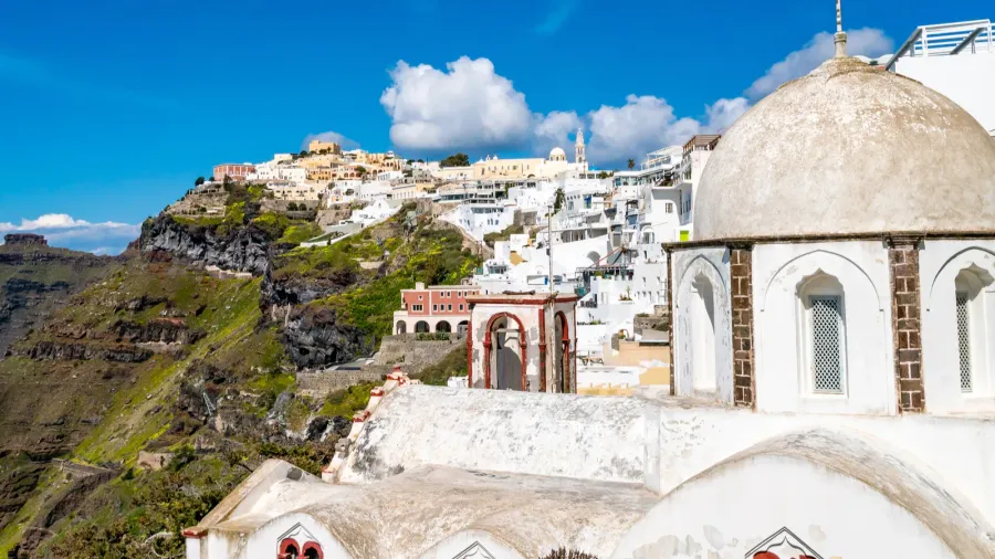 sunlight on church near white houses in greek island