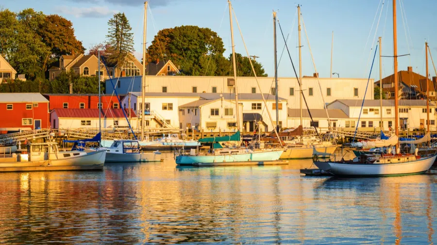 sunset over a harbour with anchored fishing and sailing boats