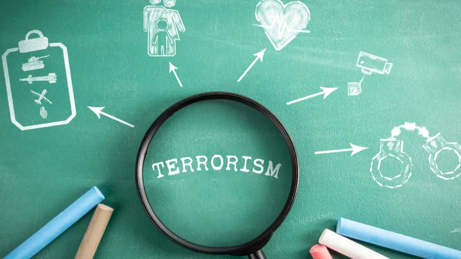 terrorism magnifying glass on green school blackboard background