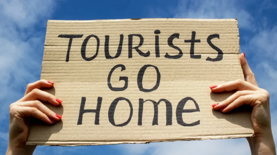 text tourists go home on a cardboard plate in hands