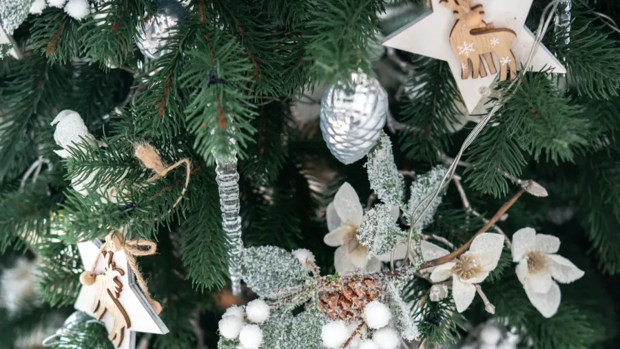 the christmas tree is elegantly adorned with wooden ornaments frosted