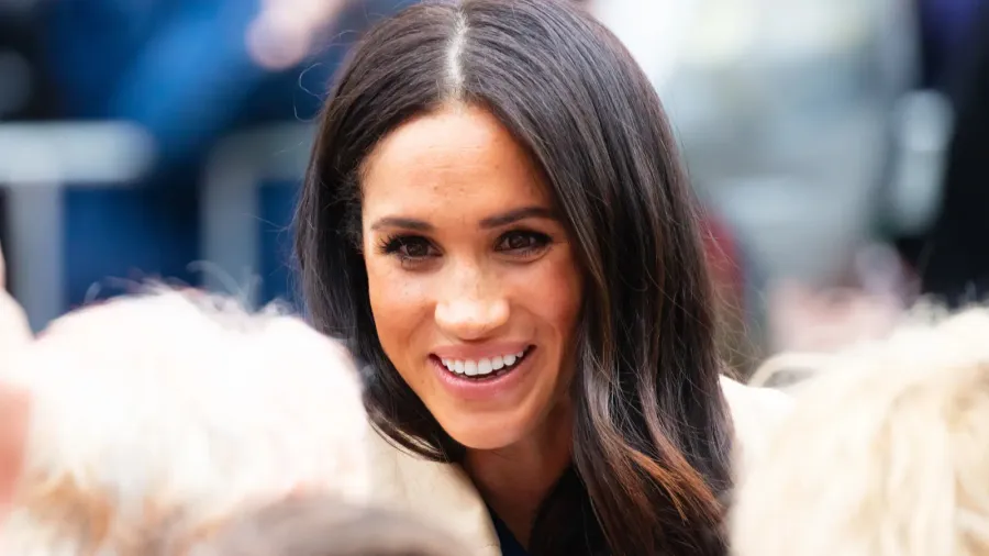 Meghan Markle smiling and engaging with a crowd.