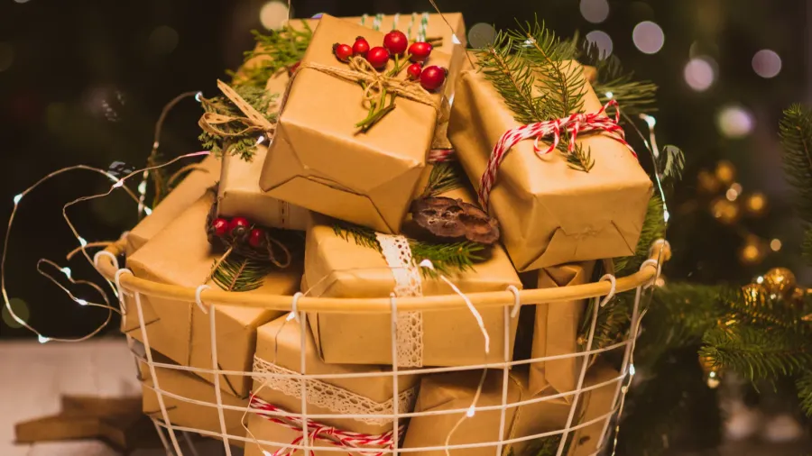 A basket filled with gifts, wrapped with fairy lights.