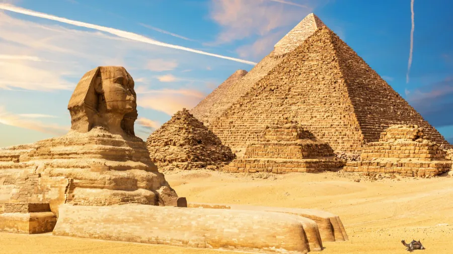 the sphinx next to the pyramids in the sands of