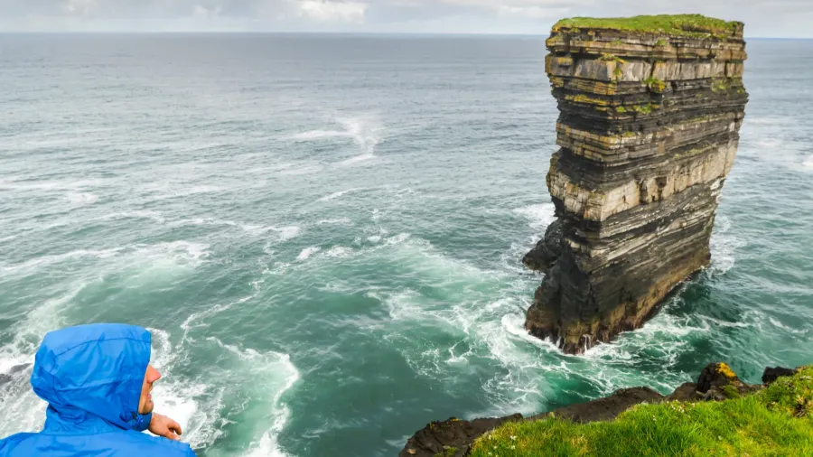 tourist in blue jacket is looking to the downpatricks head