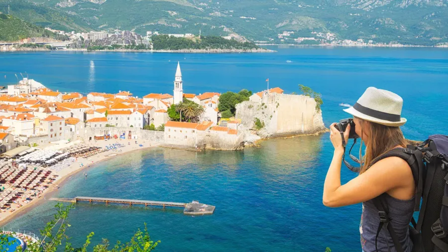 tourist taking photo of old towt budva