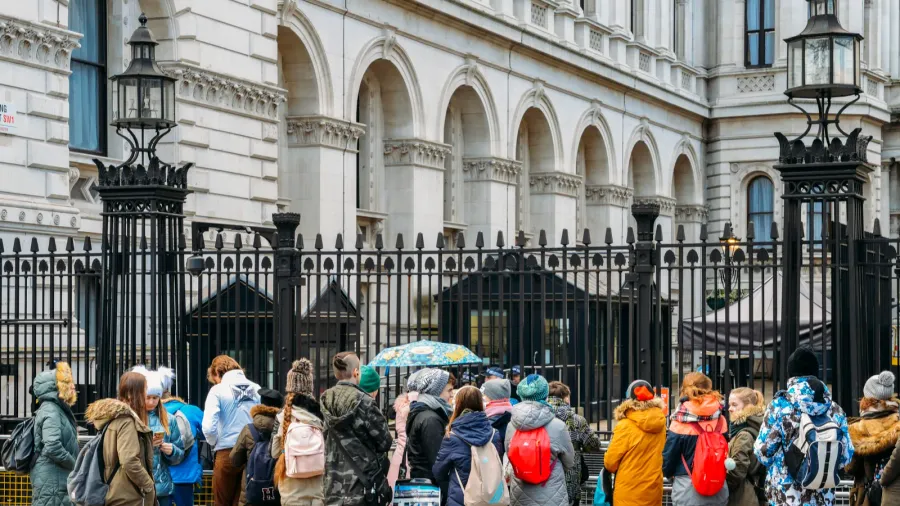 tourists in front of the gated entrance to 10 downing