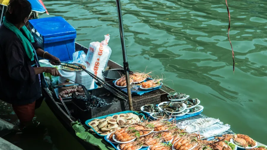 traders boats in a floating market in thailand