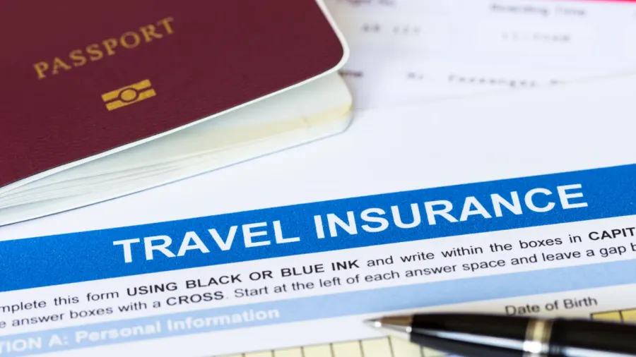 travel insurance application form with pen and passport