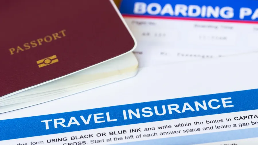 travel insurance application form with pen and passport