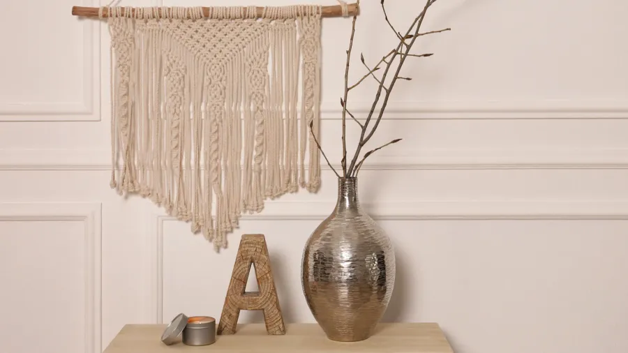 tree twigs in metal vase and decor on wooden table