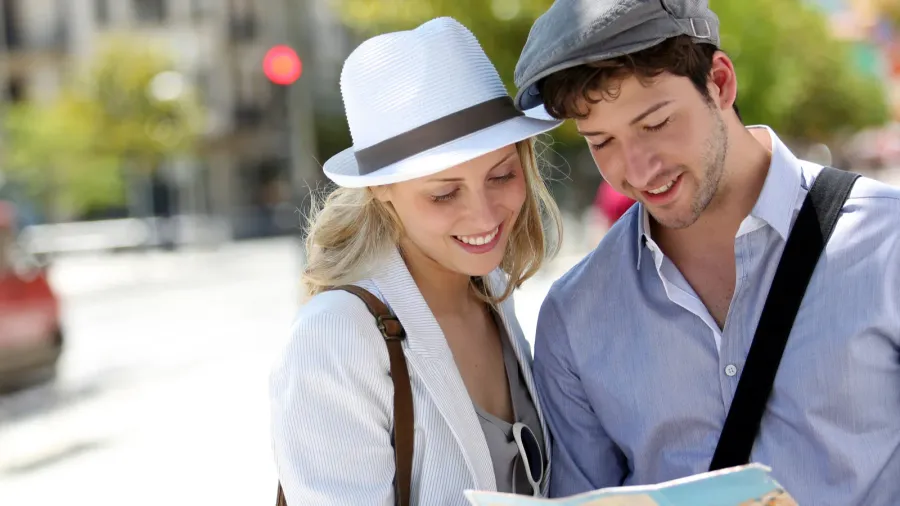 trendy young couple in town with touristic map