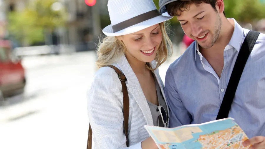 trendy young couple in town with touristic map