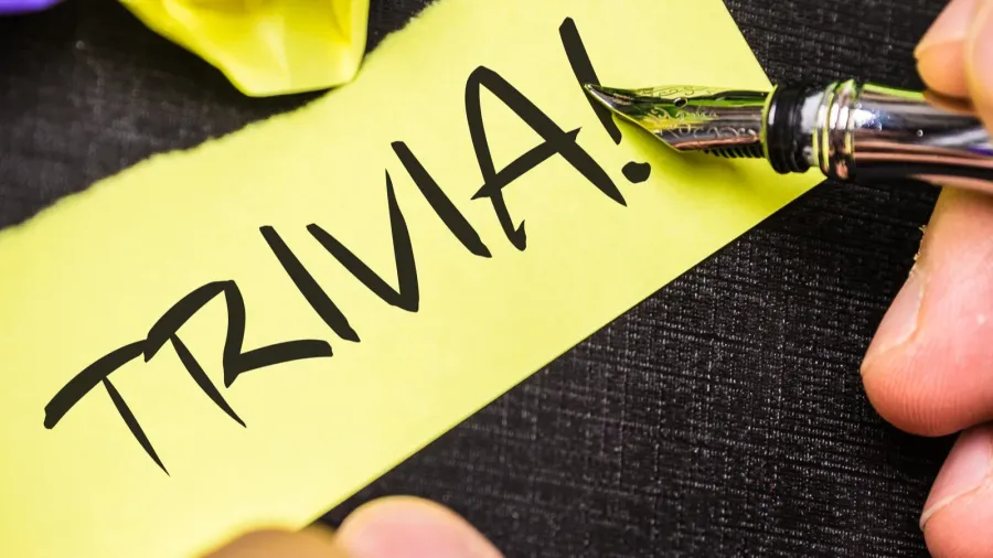 A close-up of a note with "TRIVIA!" written on it, with a fountain pen nearby.