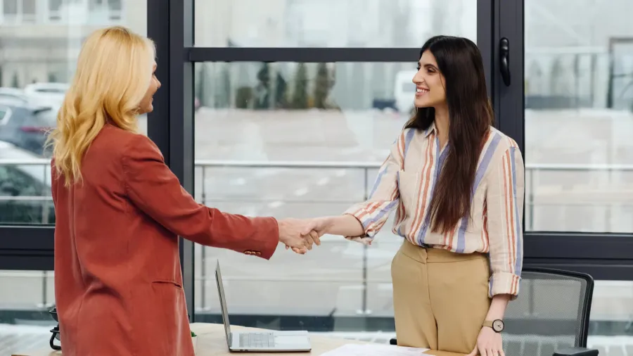 two hardworking women in an office sealing a deal through