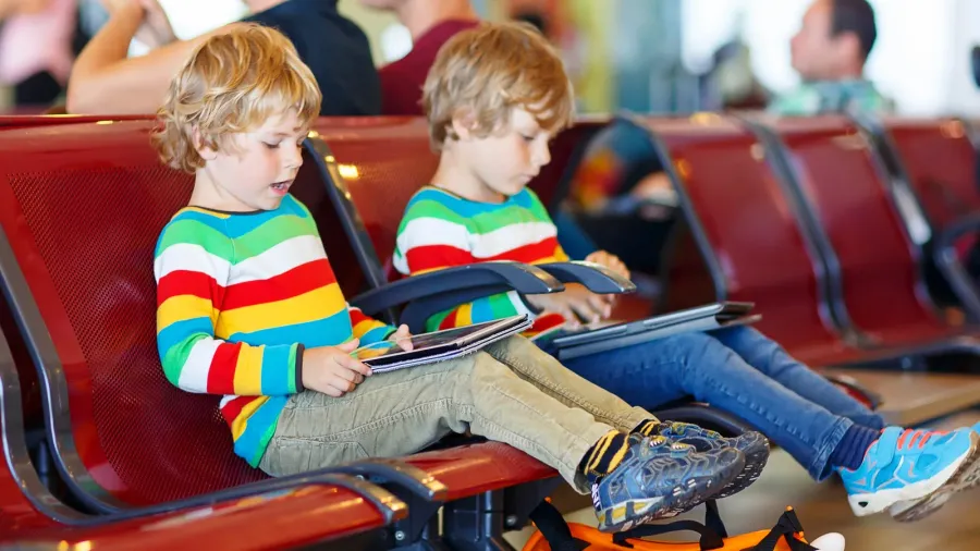 two tired little sibling boys at the airport