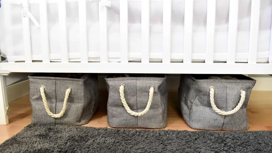 Gray storage bins under a bed.
