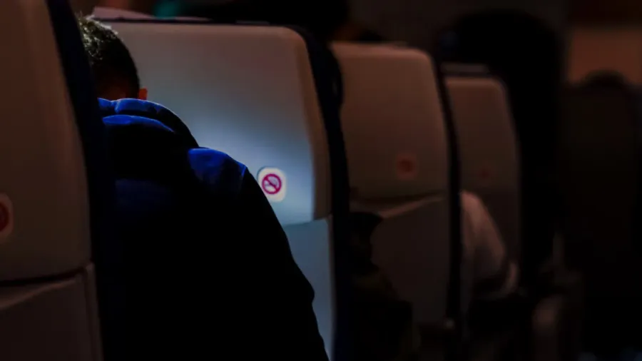traveler reading something inflight on the plane with dark