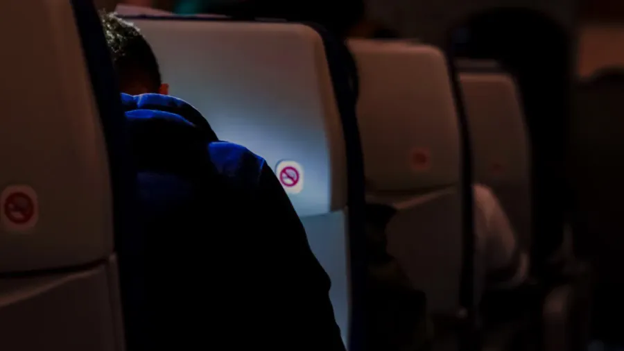 traveler reading something inflight on the plane with dark