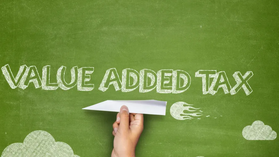 value added tax concept on blackboard with paper plane