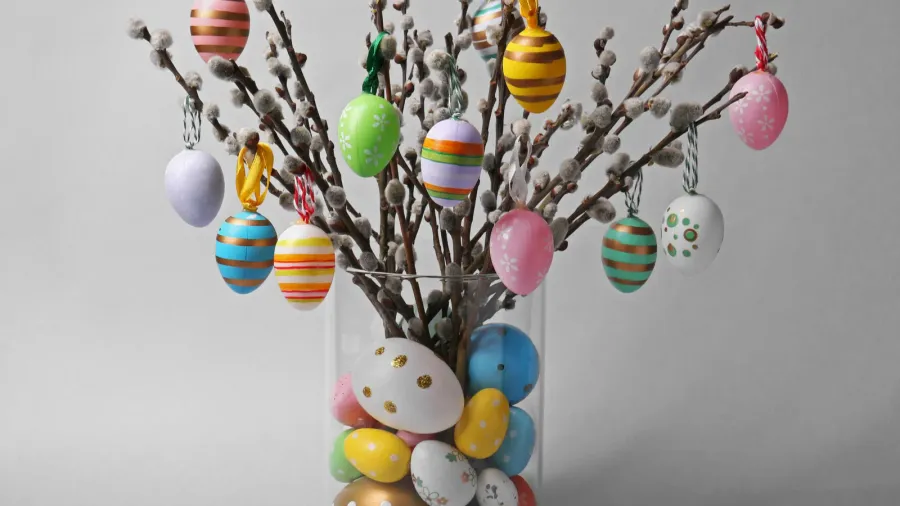 vase with beautiful willow branches and painted easter eggs on