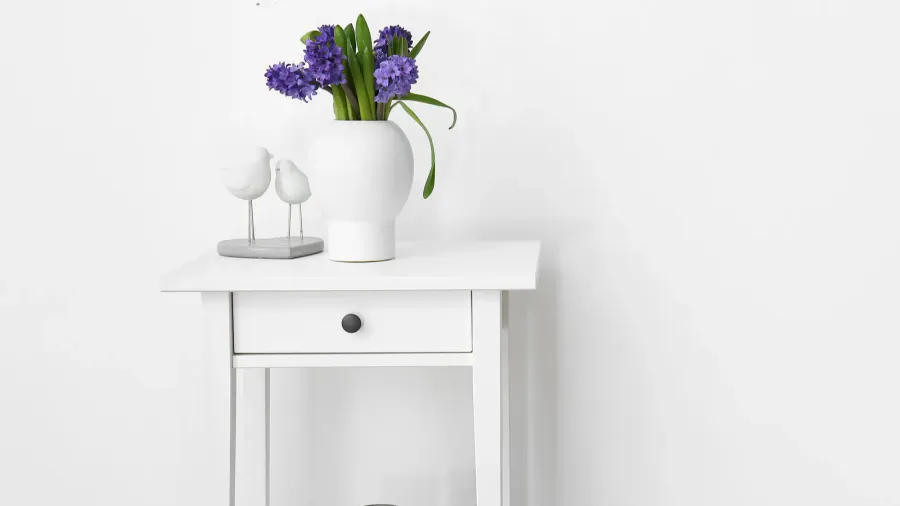 vase with flowers and stylish decor on standing desk near
