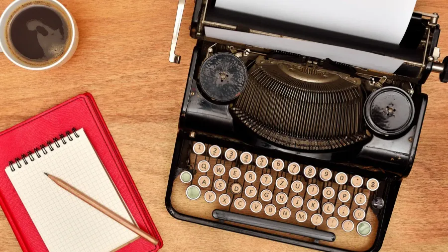 vintage typewriter cup pencil and red notebook
