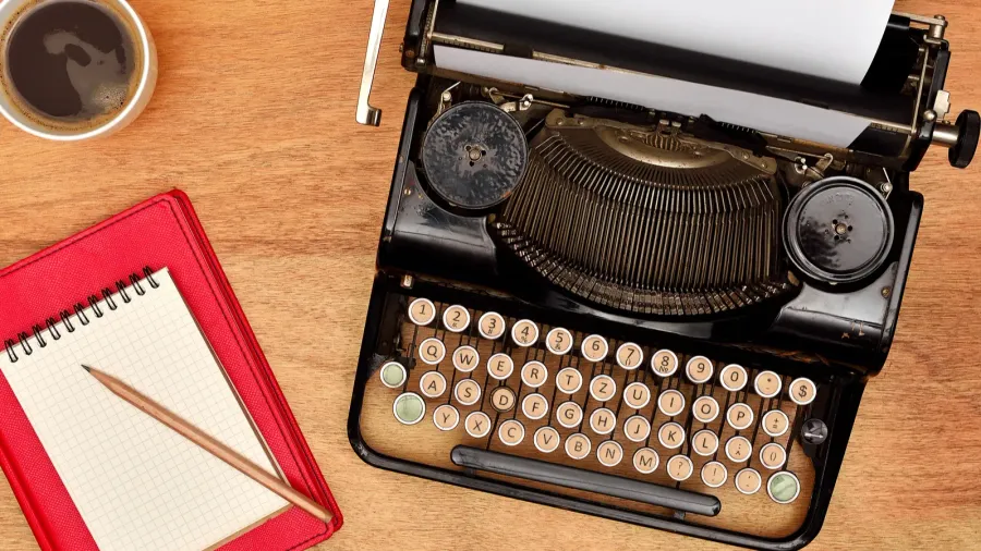 vintage typewriter cup pencil and red notebook