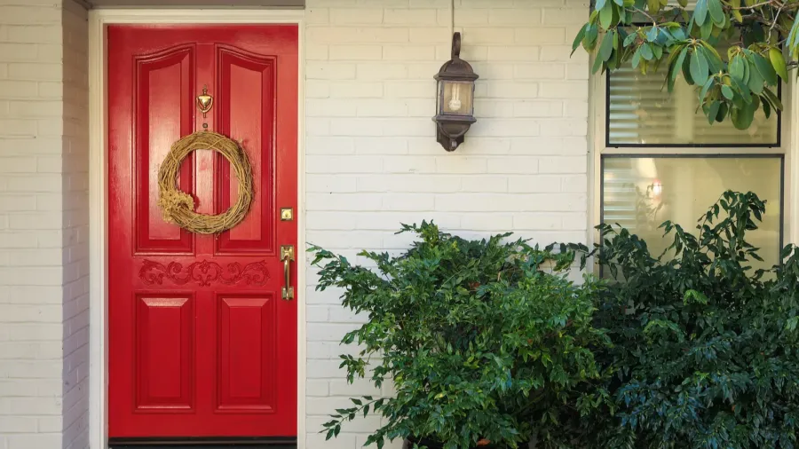 white brick front porch with red door