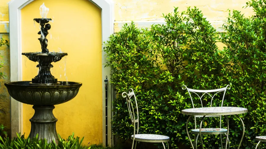 A patio with self circulating fountain water feature near sitting area.