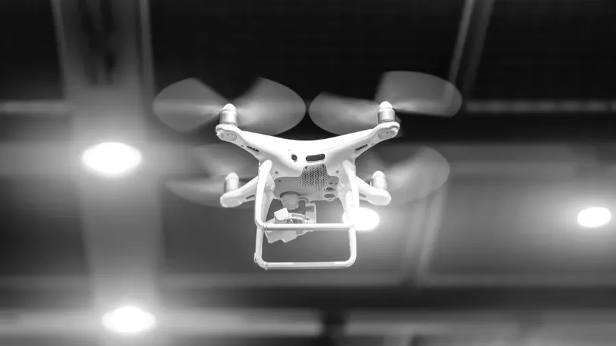 white drone in motion quadcopter flying inside a large warehouse