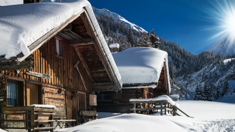 winter ski chalet and cabin in snow mountain landscape