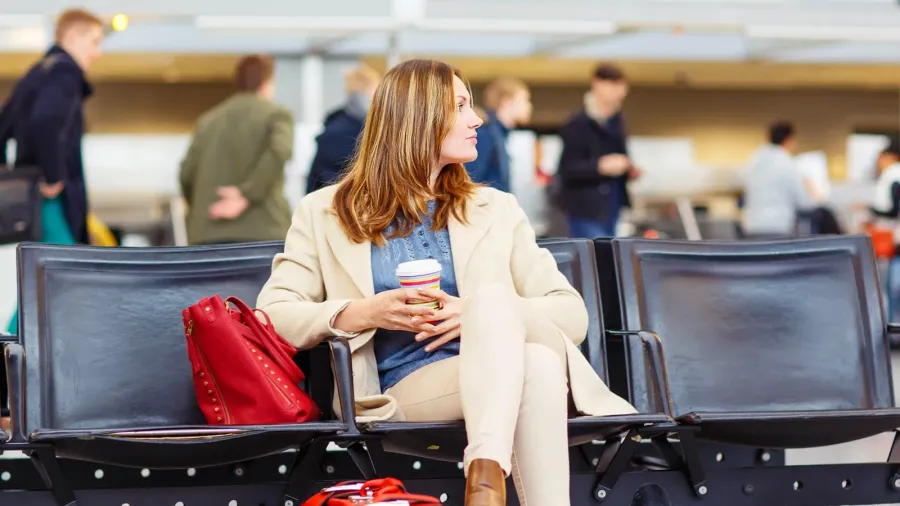 woman at international airport waiting for flight at terminal